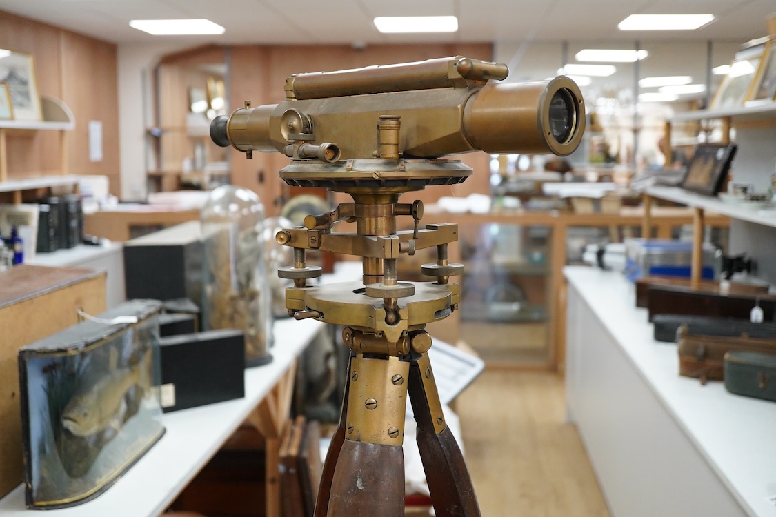 An early 20th century surveyor’s brass theodolite by Stanley, Holborn, London, serial number 27108, on original brass mounted tripod with oak legs, overall height 170cm